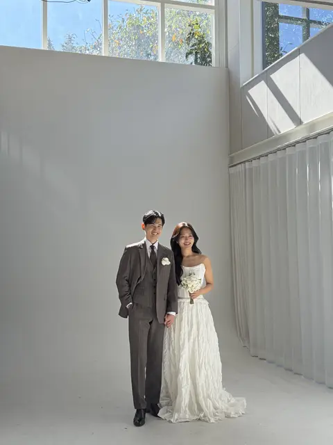 스튜디오에서 손을 잡고 웃는 두 사람